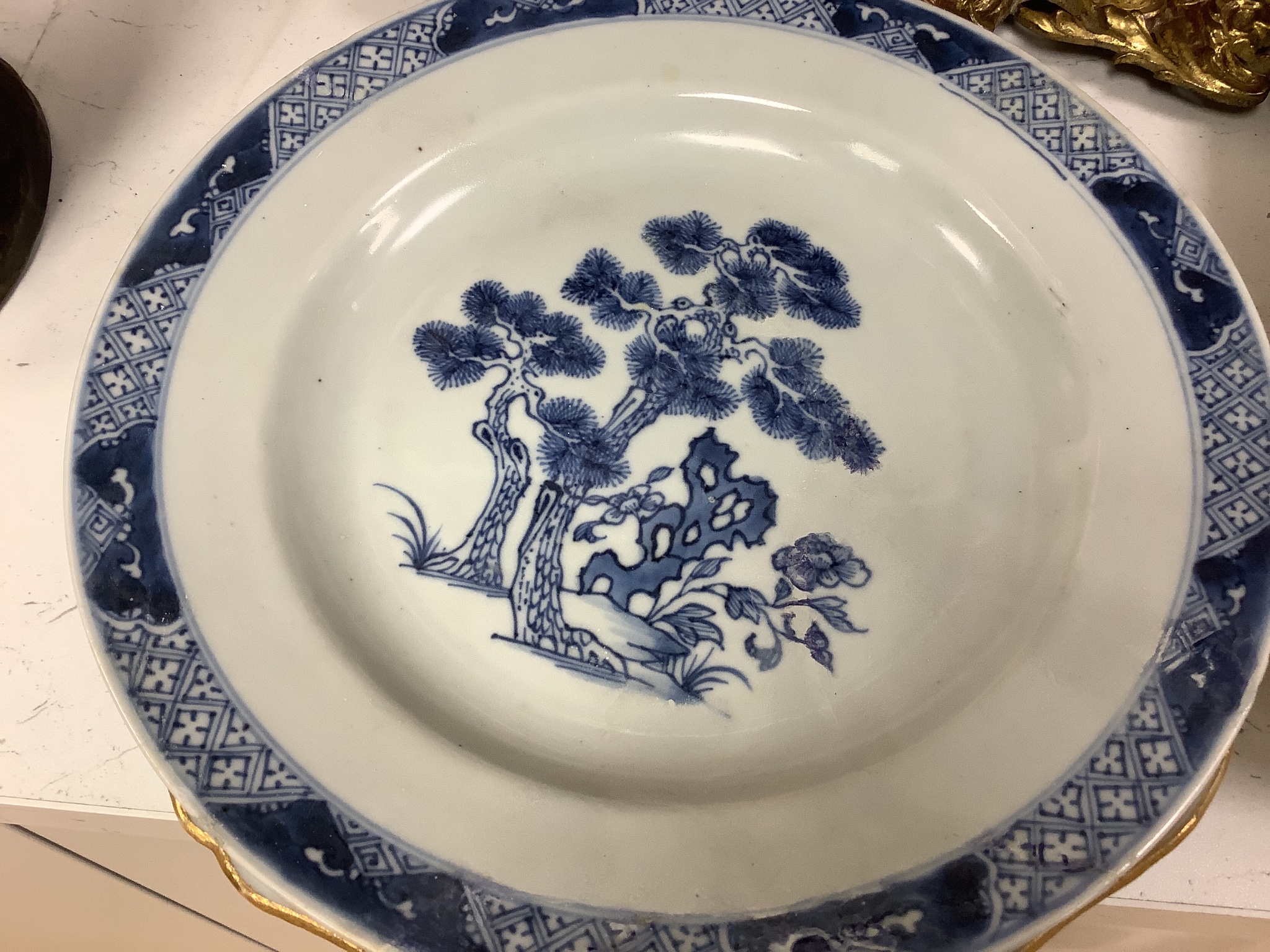 A Chinese export armorial soup plate, a large 18th century Chinese export porcelain footed punch bowl on stand, A Chinese blue and white plates and a pearlware plate